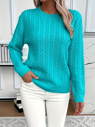 Pull à torsades bleu turquoise, encolure ronde côtelée, manches longues, porté avec pantalon blanc
