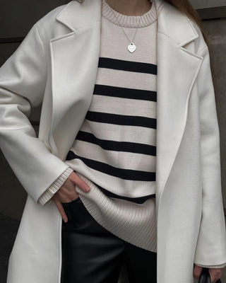 Blouse en maille blanche rayée noir, col ras du cou côtelé, bas de manche en côtes.