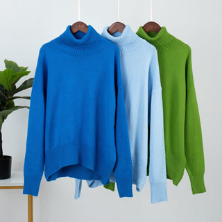 Trois pulls en tricot col montant sur cintres : bleu, bleu clair et vert