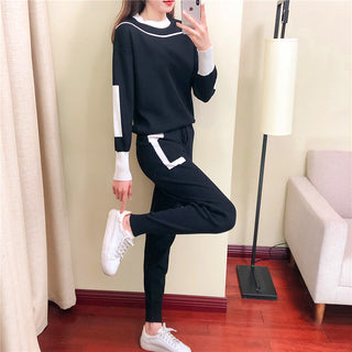 Ensemble blouse et pantalon maille légère noir, manches contrastées blanches et pantalon ajusté.