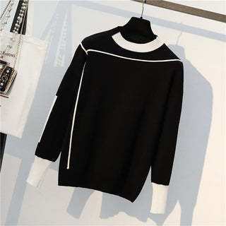 Blouse en maille noire du même ensemble, col rond blanc et poignets contrastés.