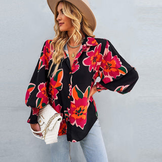 Chemise noire à fleurs multicolores, manches bouffantes, col ouvert boutonné