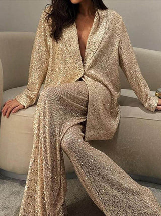 Blazer long en sequins dorés, décolleté en V, fermeture croisée et épaules amples.