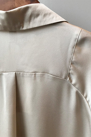 Blouse en satin champagne gros plan sur l’empiècement au niveau du haut du dos.