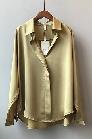 Blouse en satin champagne, col chemise et boutons, portée sur cintre