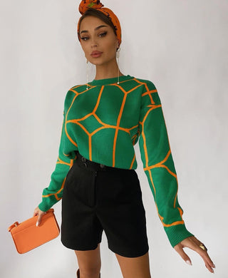 Blouse en maille verte à motifs géométriques orange, col rond, manches longues, coupe ample.