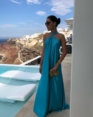 Robe maxi dos nu satinée bleu turquoise, encolure halter nouée, jupe ample