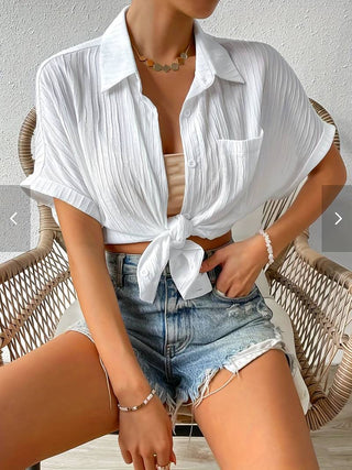 Chemisier blanc ample noué devant, col chemise, manches courtes, poches discrètes