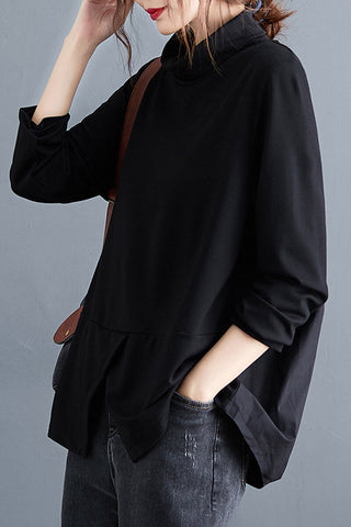 Blouse noire col montant, manches longues, ourlet évasé, poche avant