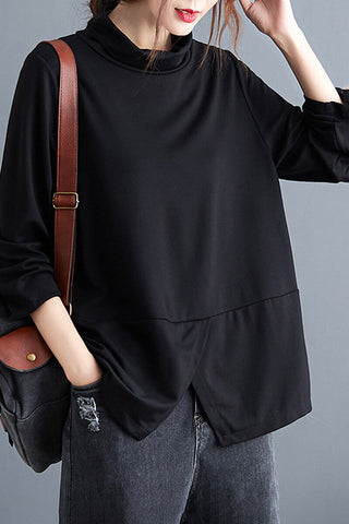 Blouse noire à col montant, coupe ample, couture bas arrondie, poche discrète