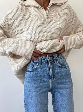 Pull en tricot beige clair, col montant et demi-fermeture éclair, manches longues côtelées.