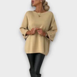Blouse en maille beige à encolure ronde, manches 3/4 boutonnées, coupe ample.