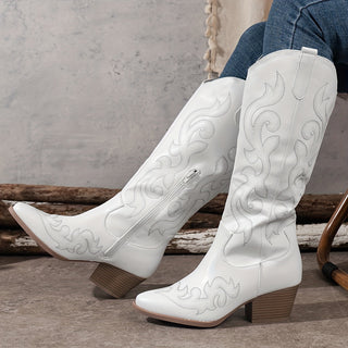 Bottes de cowboy blanches à talon bloc, bout pointu, motifs western discrets.