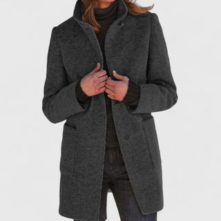 Manteau classique en laine gris foncé, fermeture boutonnée, col ouvert, poches plaquées.