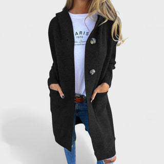 Manteau long noir à col châle, fermeture boutonnée, poches latérales visibles