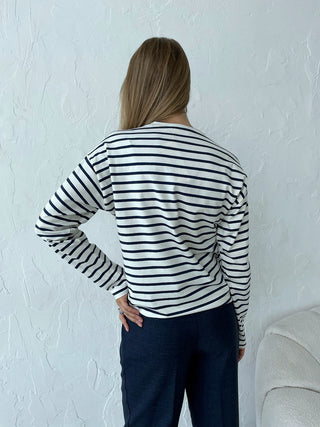 Blouse rayée manches longues bleu marine et blanc, dos visible, encolure ronde.