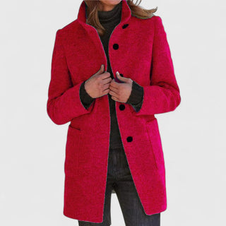 Manteau classique en laine rouge, fermeture boutonnée, col ouvert, poches plaquées.