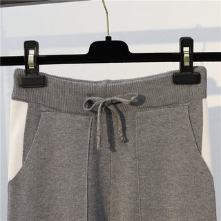 Pantalon en maille gris, taille à cordon et empiècements latéraux contrastés.