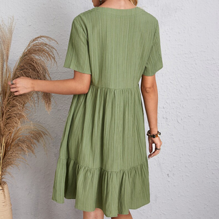 Robe d’été bohème verte au dos, manches courtes évasées et volants à la base.