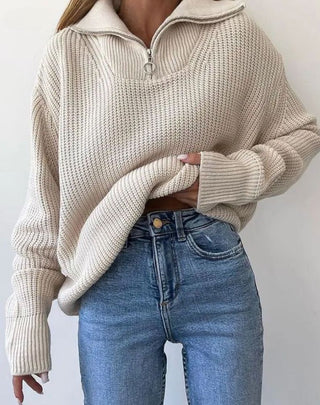 Pull en tricot beige clair, col montant et fermeture éclair, manches longues côtelées.
