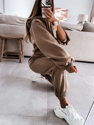 Ensemble sweat à capuche et pantalon beige, détails froncés et chevilles resserrées.