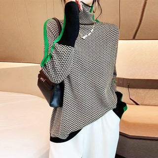 Blouse manches longues col montant à motif chevrons noir et blanc, touches orange et marron.