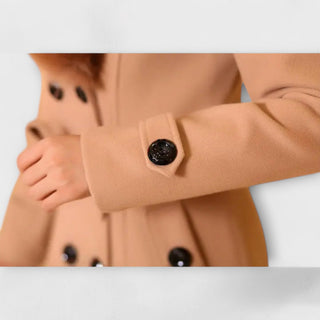 Détail manteau d’hiver camel : boutons noirs ronds et fermeture mi-longue