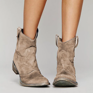 Bottes western en daim brun clair à hauteur de cheville, tirants latéraux.