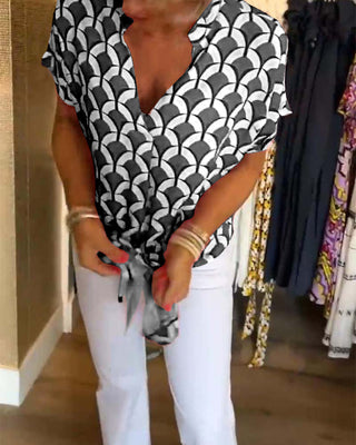 Chemisier décontracté à manches courtes, encolure V, motif géométrique noir et blanc.