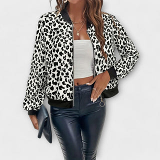 Veste courte zippée imprimé léopard blanc et noir, col montant, manches longues, poignets noirs.