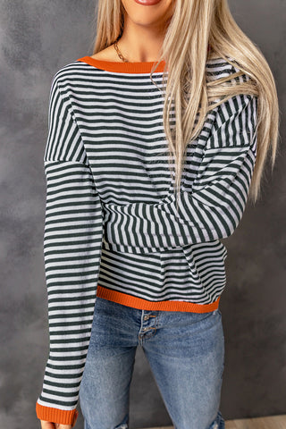 Blouse rayée bleu marine et blanche à manches longues, bord orange sur l’ourlet.