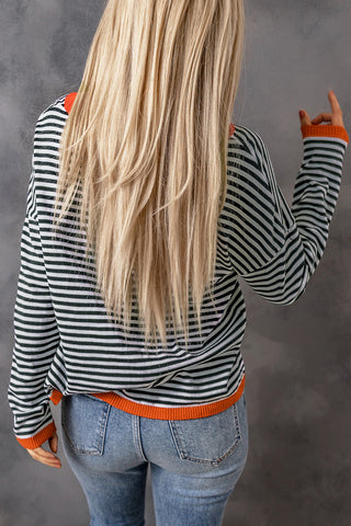 Blouse rayée bleu marine et blanche, dos avec bord orange au col et à l’ourlet.