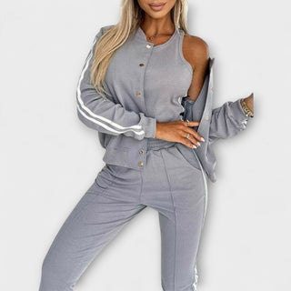 Ensemble veste et pantalon gris à bandes blanches, manches épaules dénudées, boutons.