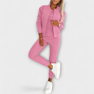 Ensemble veste et pantalon rose à bandes blanches, manches longues, haut boutonné.