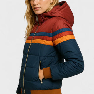 Veste imperméable matelassée côté avec capuche, zip, rayures horizontales et poche zippée.