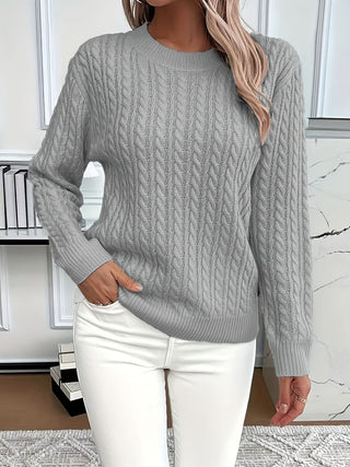 Pull à torsades gris, encolure ronde côtelée, manches longues, porté avec pantalon blanc