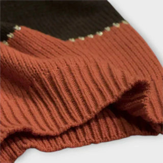 Détail du pull en maille côtelée, bord chevrons marron rouille