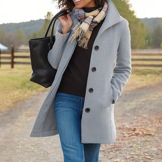 Manteau long gris clair à boutons, col tailleur, coupe droite.