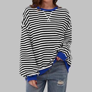 Haut rayé noir et blanc à manches longues, encolure ronde avec bord bleu contrasté.