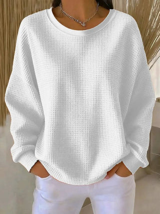 Pull en tricot blanc à col rond, manches longues, texture grainée, poignets côtelés.