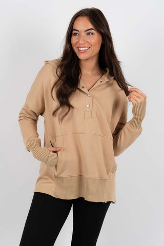 Sweat-blouse beige à col en V boutonné, poignets et bas côtelés, coupe ample.