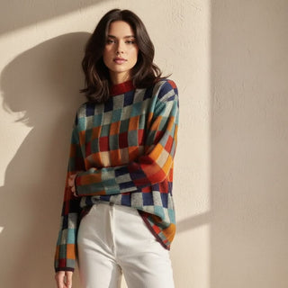 Pull en mérinos à carreaux multicolores, col montant rouge, porté avec manches longues.