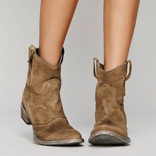 Bottes western en daim brun à hauteur de cheville, talon bloc et tirant à la cheville.