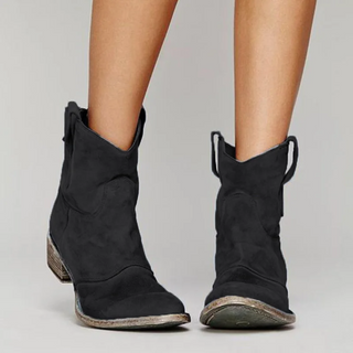Bottes western en daim noir à hauteur de cheville, tirants latéraux et talon bloc.