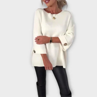 Blouse en maille blanche à encolure ronde, manches 3/4 boutonnées, coupe ample.