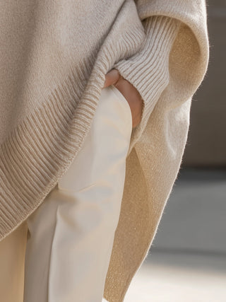 Poncho femme oversize beige en maille, détail bord côtelé et ouverture sur le côté