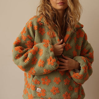 Pull quart de zip en polaire vert olive à fleurs orange, motif floral sur tout le buste.