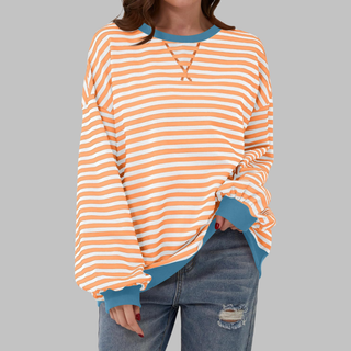 Haut rayé orange et blanc à manches longues, encolure ronde avec bord contrasté bleu-vert.