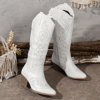 Bottes de cowboy blanches à talon bloc, bout pointu, motifs brodés ton sur ton.