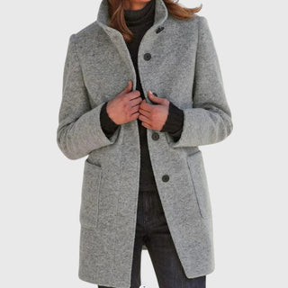 Manteau classique en laine gris, fermeture boutonnée, col ouvert, poches plaquées.